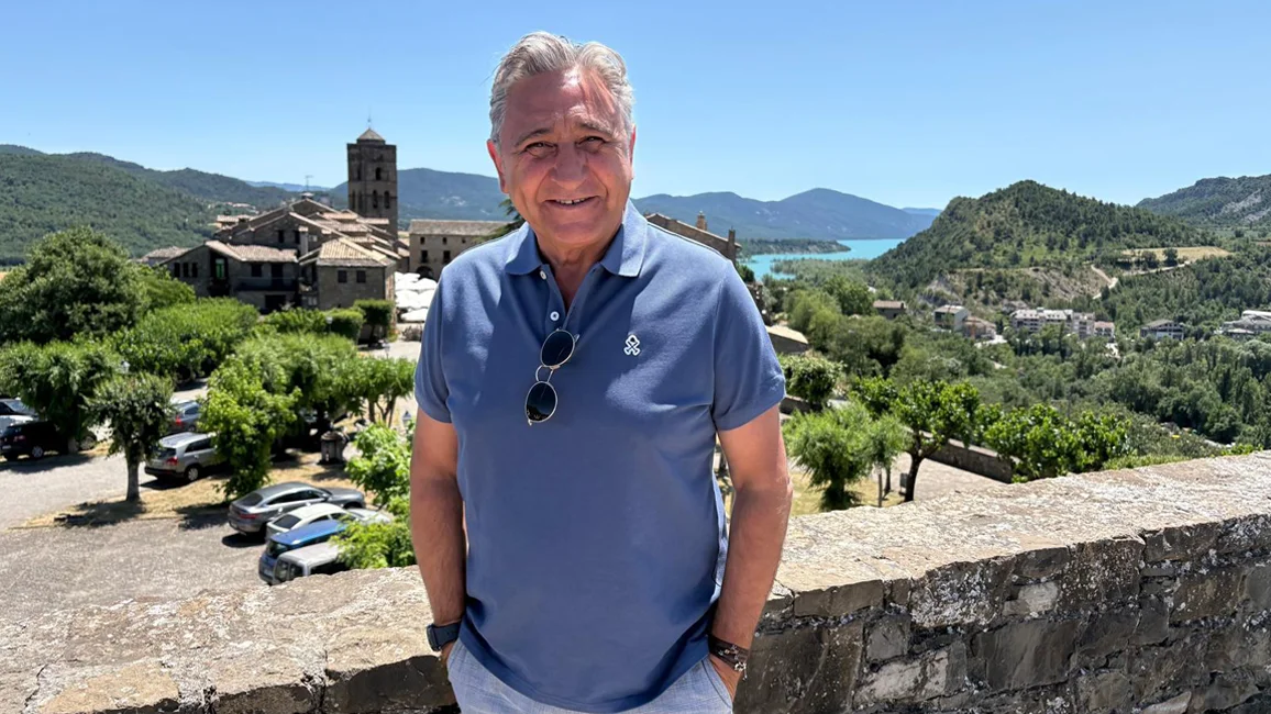 Javier Segarra sonriendo a cámara con bello pueblo de fondo